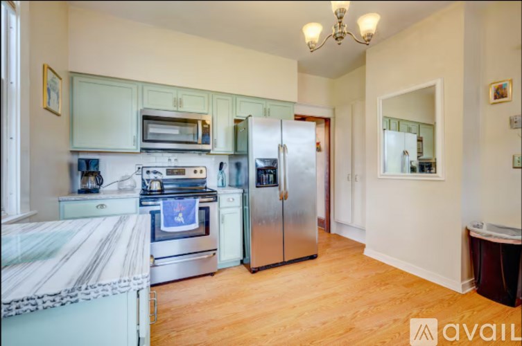 A kitchen with a refrigerator, oven, and microwave.
