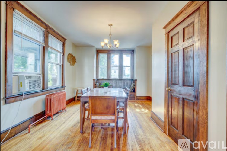 A wooden table and chairs are set up in a room with a window and a radiator.