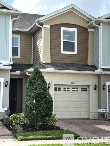 A two-story house with a garage and a driveway.