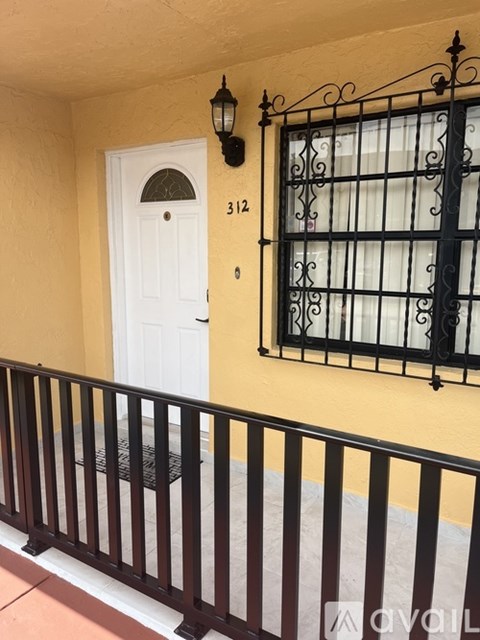 A white door with a window above it and a black railing below it.