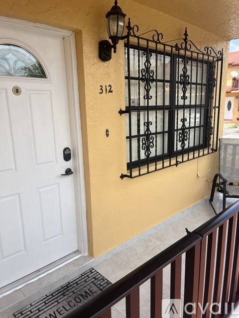A white door with a black gate and a number 312 on the wall.