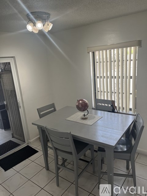 A dining room with a table and chairs.