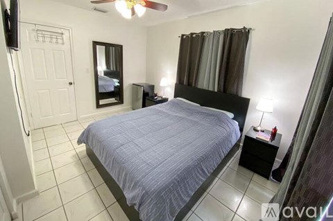 A bedroom with a bed, nightstand, and a ceiling fan.