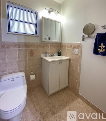 A bathroom with a white toilet and a sink with a cabinet above it.