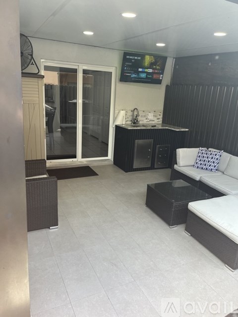 A modern living room with a television and a couch.