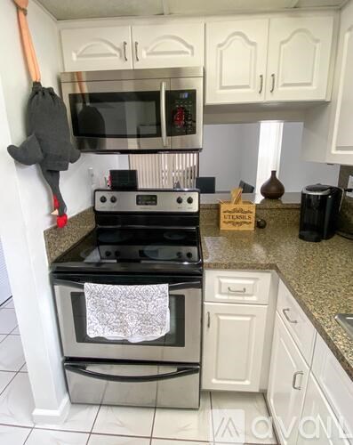 A black and white stove with a white towel hanging on it.