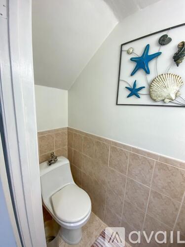 A bathroom with a toilet and a picture of sea life on the wall.