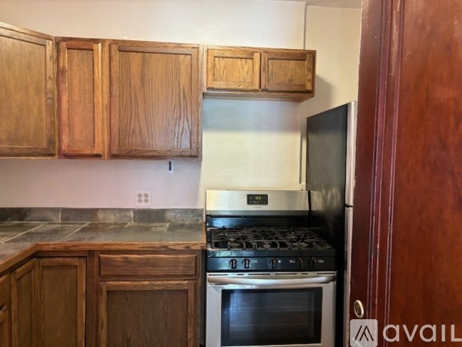 A kitchen with wooden cabinets and a white stove top oven.