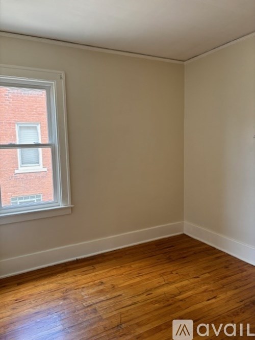 A room with a window and wooden flooring.