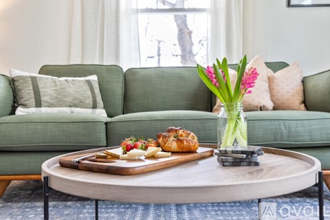 A table with a vase of flowers and a tray of pastries on it.