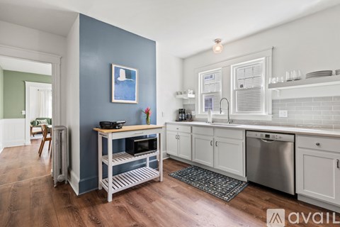 A kitchen with a blue wall and white cabinets.