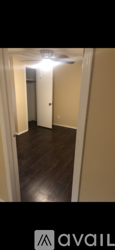 A hallway with a light on and a door at the end.