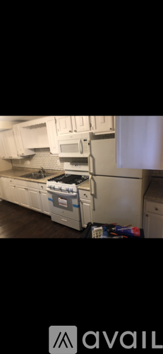 A kitchen with white cabinets and appliances.
