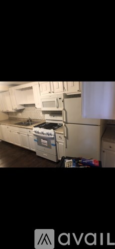 A kitchen with white cabinets and appliances.