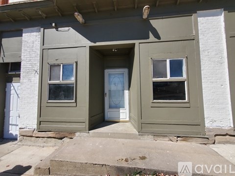 A house with a grey front and a white door.
