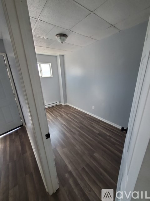 A room with wooden flooring and white walls.