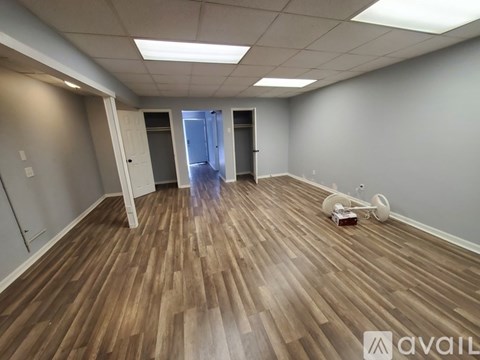 A room with wooden flooring and white walls is available for rent.