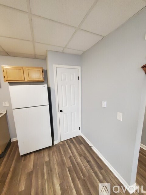A kitchen with white appliances and a white door.