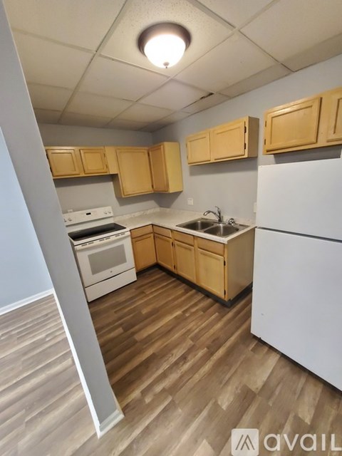 A kitchen with wooden cabinets and a white refrigerator.