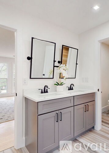 A bathroom with a double sink vanity and a large mirror.