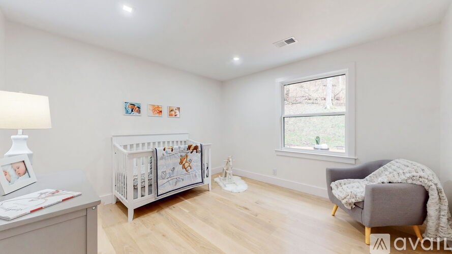 A baby nursery with a crib, chair, and pictures on the wall.