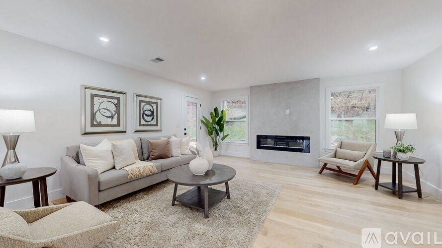 A modern living room with a grey sofa, a coffee table, and a fireplace.