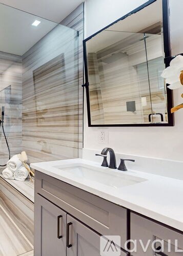 A modern bathroom with a white sink and a mirror above it.