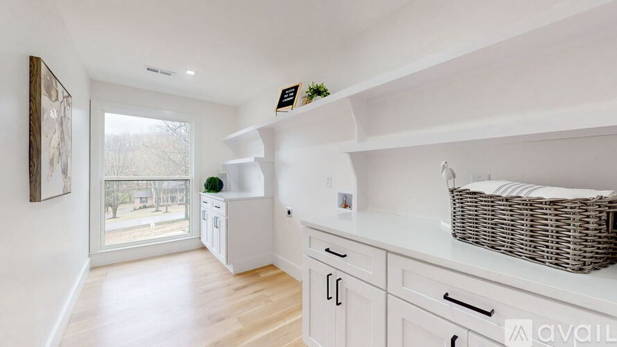 A kitchen with white cabinets and a basket on the counter.