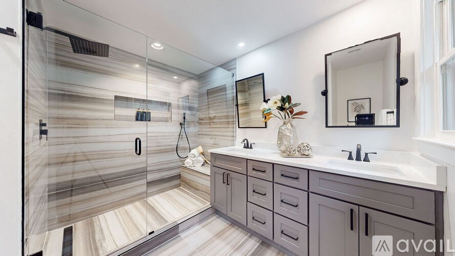 A modern bathroom with a walk-in shower and double sinks.
