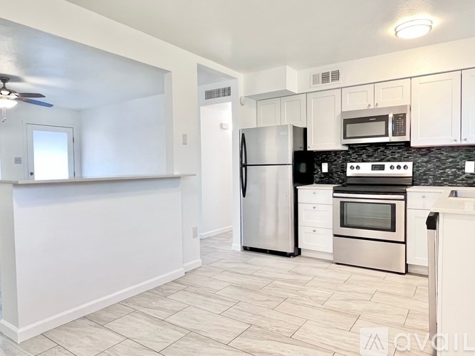 A kitchen with white cabinets and a black stove top oven.