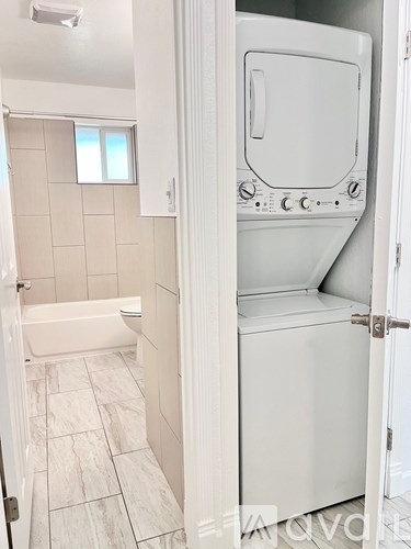 A white bathroom with a white tiled floor and a white cabinet.