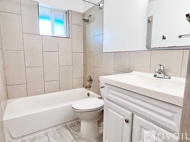 A white bathroom with a tub, toilet and sink.