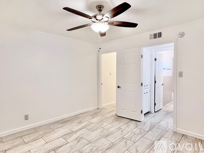 A room with a ceiling fan and tile flooring.