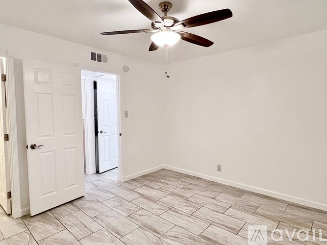 A room with a ceiling fan and tile flooring.