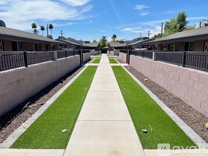 A long concrete walkway with grassy areas on either side.