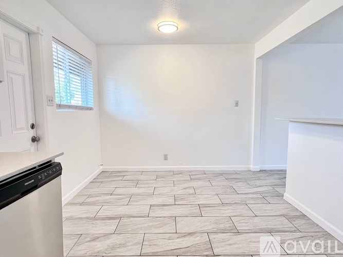 A kitchen with a dishwasher and a window.