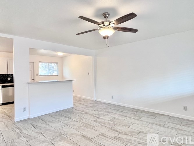 A spacious room with a ceiling fan and tiled flooring.