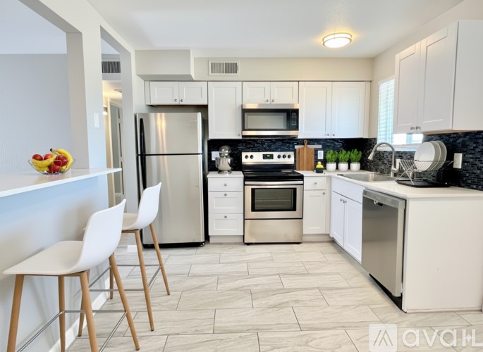 A modern kitchen with white cabinets and appliances.