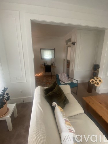 A living room with a white couch and a small table.