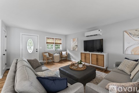 A living room with a grey couch and a wooden cabinet.