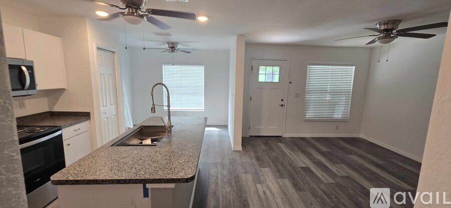 A kitchen with a granite countertop and a fan ceiling.