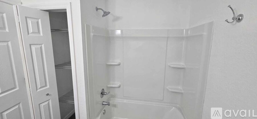 A white bathroom with a glass shower door and a white cabinet.