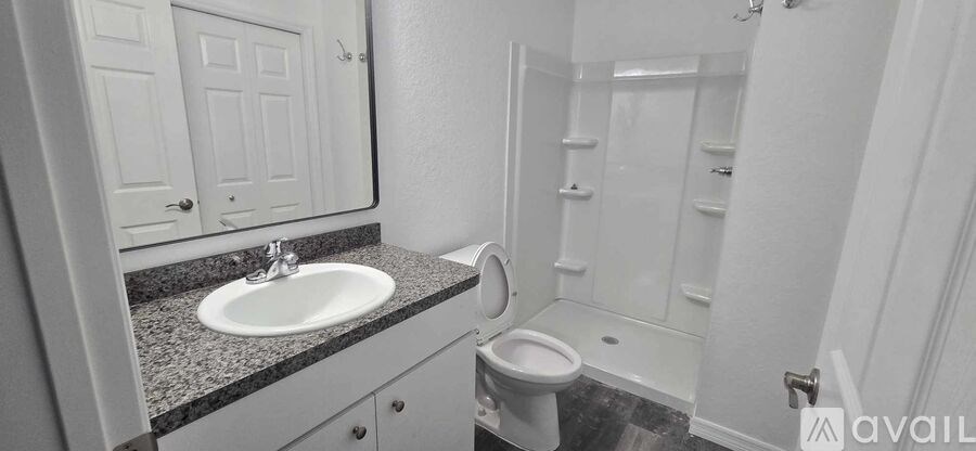 A bathroom with a sink, toilet and shower.