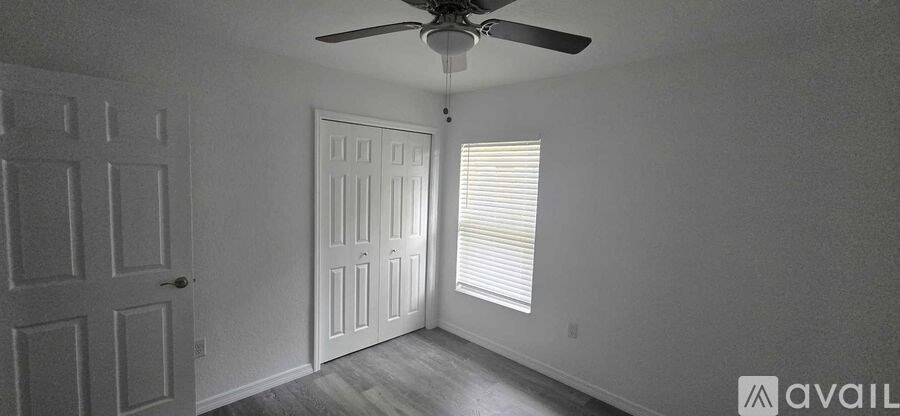 A room with a ceiling fan and two doors.