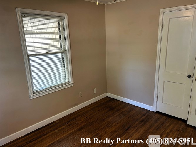 A room with a window and a door is for sale.