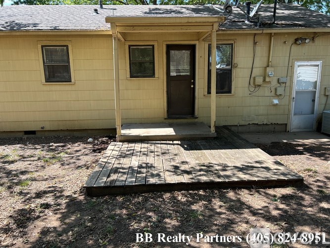 A small yellow house with a porch and BB Realty Partners written on the bottom.