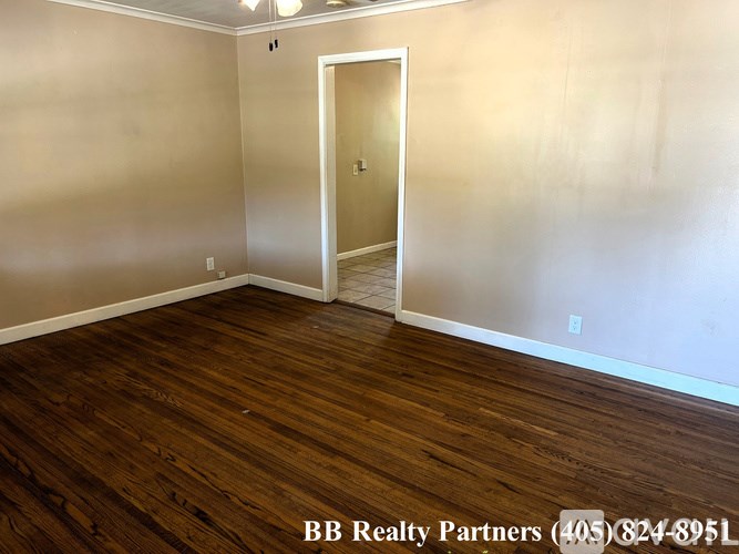 A room with wooden flooring and a white door.