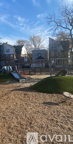 A playground with a slide and a tree in the background.