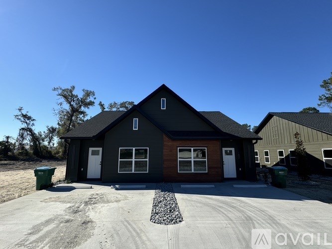 A house with a gravel driveway in front of it.