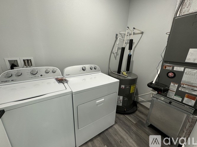 A room with two washing machines and a dryer.